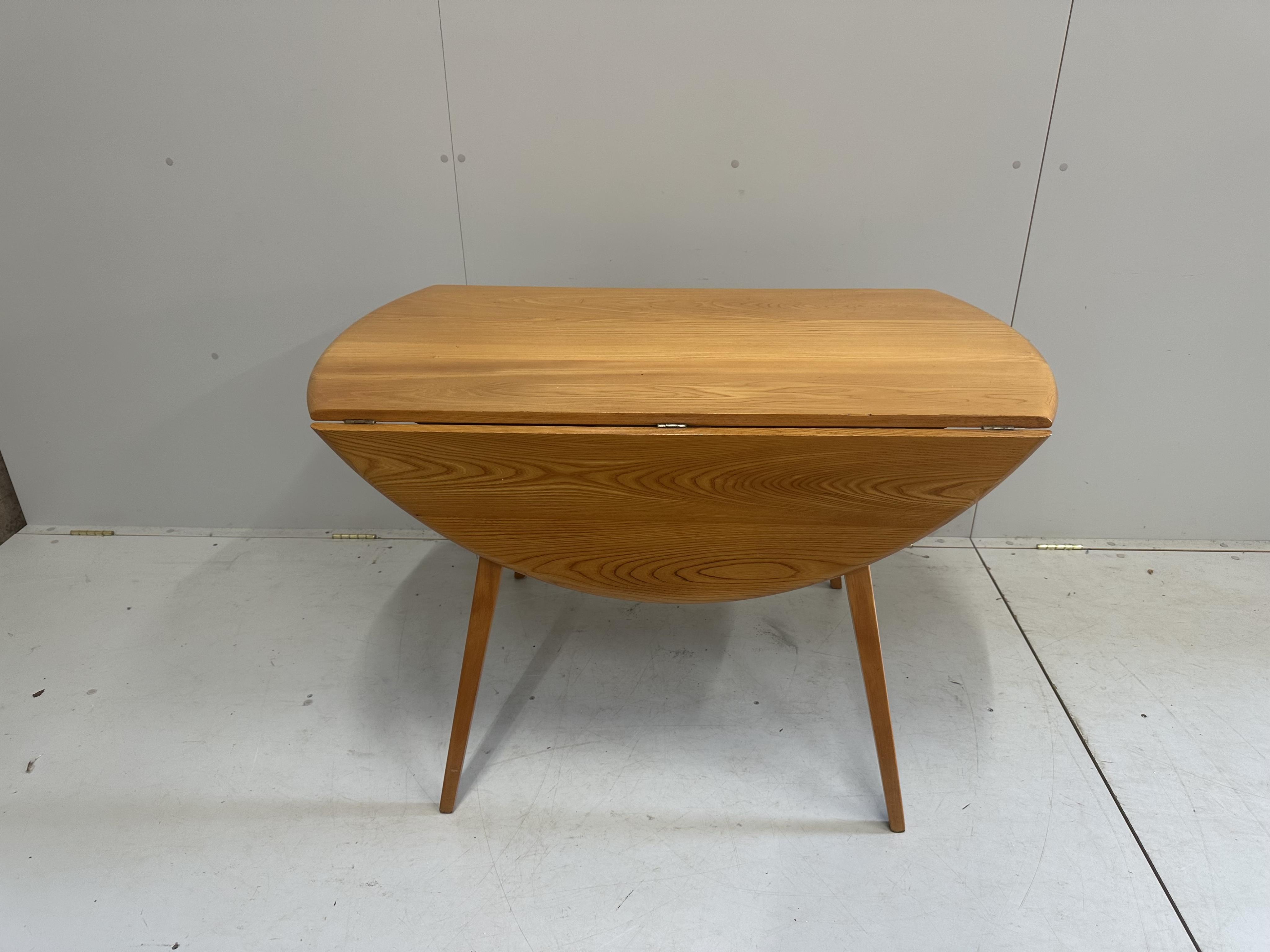 An Ercol elm oval drop leaf dining table, width 124cm extended, height 71cm, together with five Ercol elm, ash and beech dining chairs. Condition - fair to good